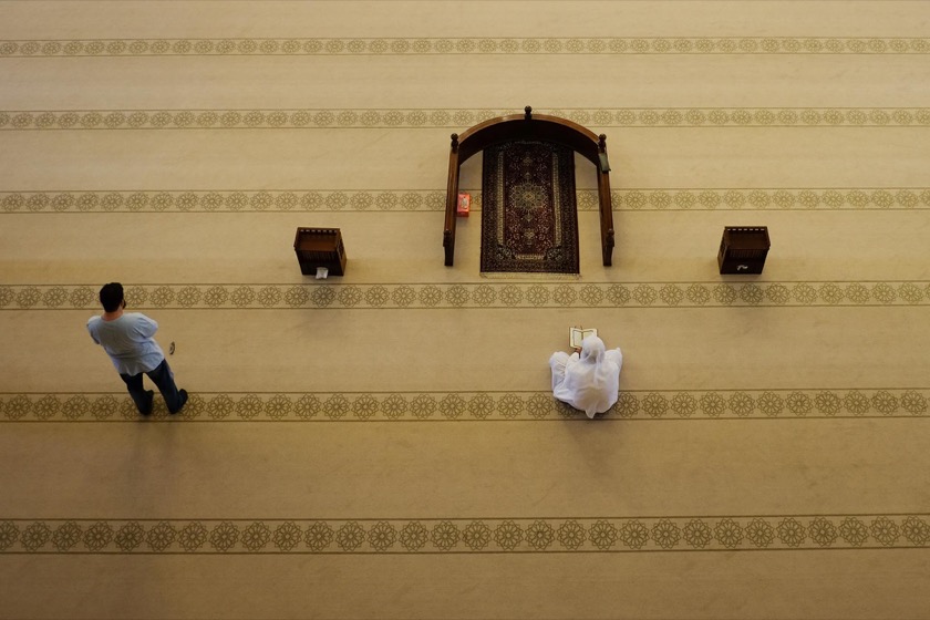 Two men praying inside the Al Fateh Grand Mosque.
